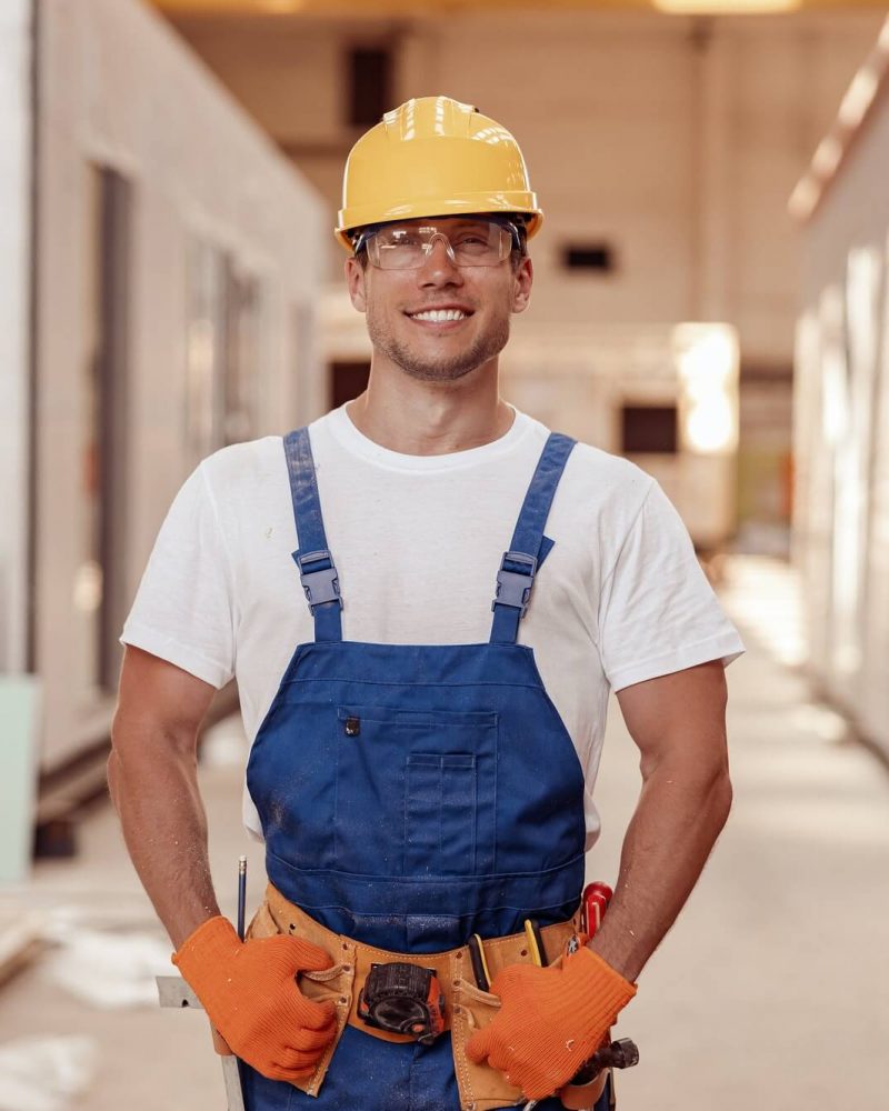 cheerful-male-builder-standing-at-construction-site-1.jpg